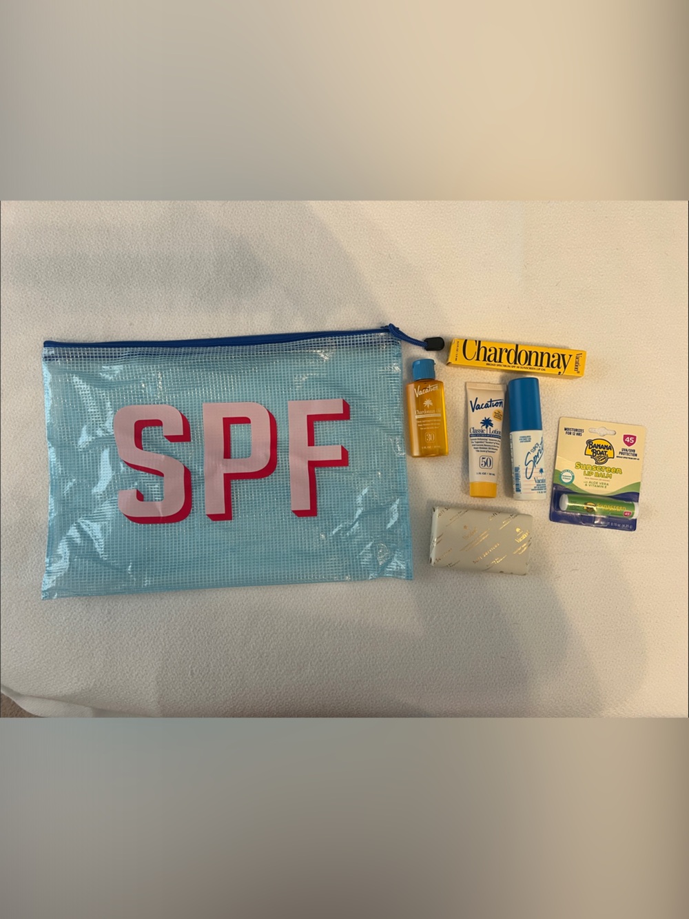 Light Blue Cosmetic Pouch with Pink 'SPF' Lettering with SPF products